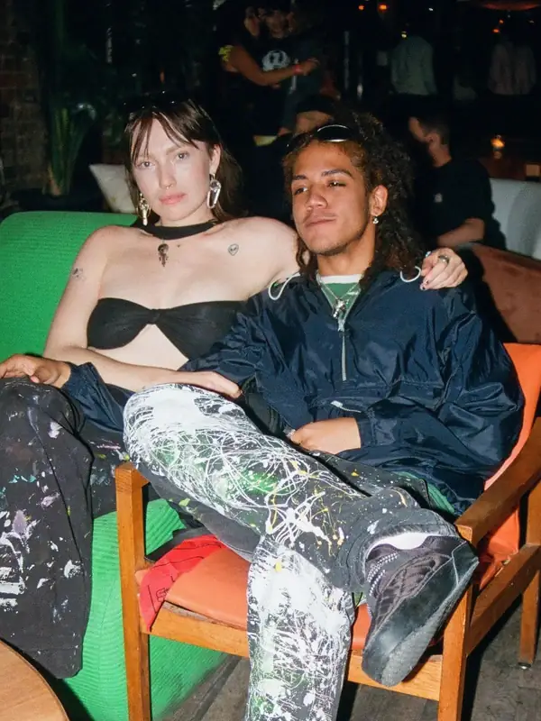 Guests relaxing on a couch at an Apt. 200 house party on Queen Street West