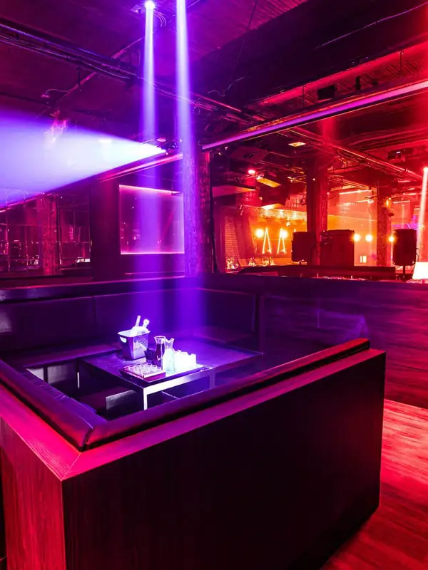 Red-lit VIP booth with bottle service at Century nightclub on King Street West