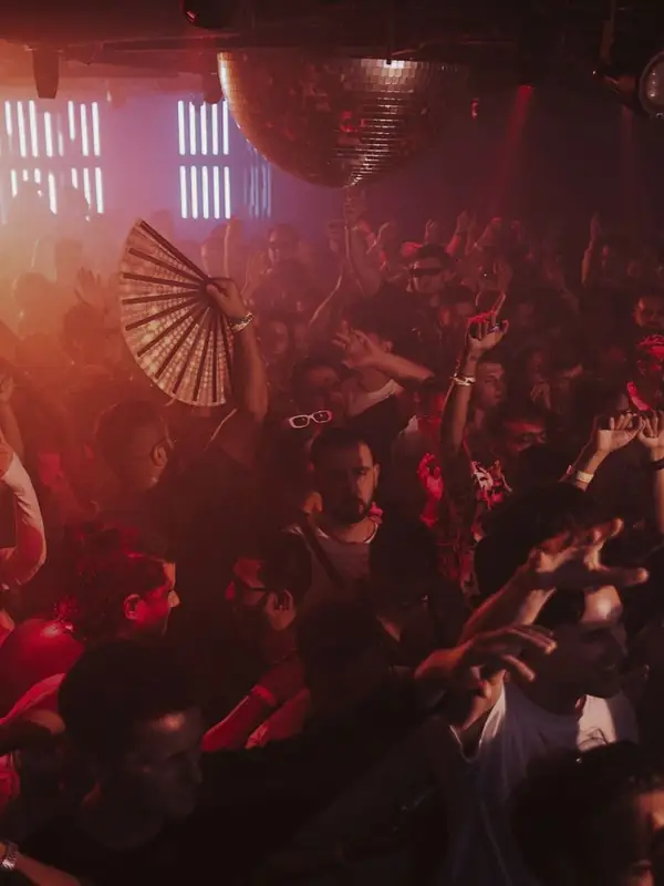 Packed dance floor under red light at Coda nightclub on Bathurst Street